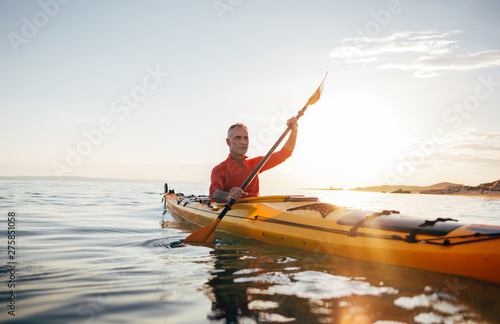 Active senior man paddling kayak
