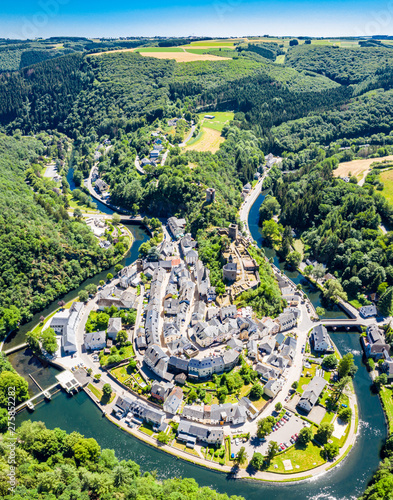 Aerial view of Esch-sur-Sure, medieval town in Luxembourg, dominated by castle, canton Wiltz in Diekirch. Forests of Upper-Sûre Nature Park, meander of winding river Sauer, near Upper Sauer Lake