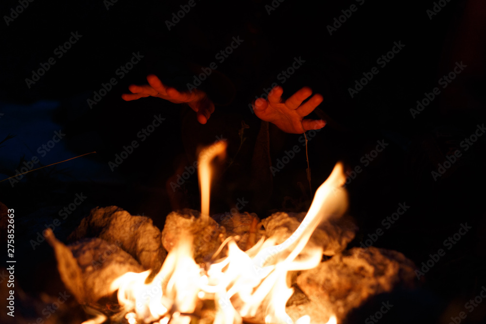 Hands over the fire in full darkness. The concept of magic.