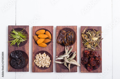 dried fruits and spices on wooden tray, white table
