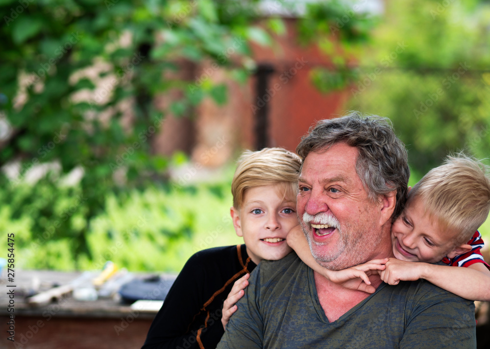 Portrait of a middle-aged Caucasian gray-haired man with a grandsons