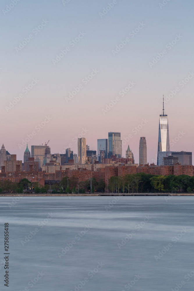 Downtown Manhattan with WTC from east river at sunrise with long exposure