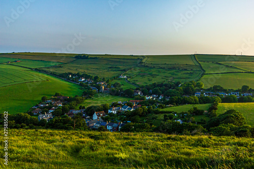 An aerial view of a rural village at sunset with majestic blue sky