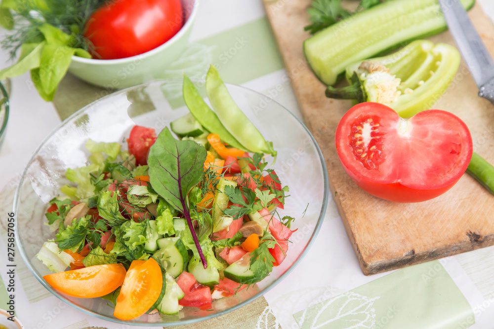 Plate with fresh mixed vegetables salad with greens close-up. Vegan vegetarian healthy food Plate with fresh mixed vegetables salad with greens close-up. Vegan vegetarian healthy food
