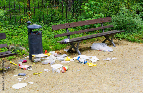 Waste besides a trash can and bench at the Grosser Garten in Dresden, Germany. Birds are the most likely culprits as they are searching for food.