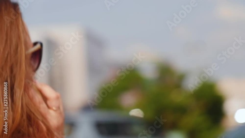Wallpaper Mural Young woman with glasses talking on the phone on the street. Close up shot. Torontodigital.ca