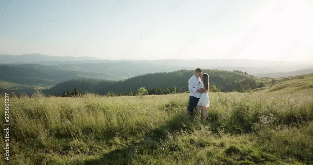 Young adorable couple embracing, kissing each other in the green dense mountain region. Summertime, sunset. Couple goals. Forever in love. Love story Young adorable couple embracing, kissing each other in the green dense mountain region. Summertime, sunset. Couple goals. Forever in love. Love story