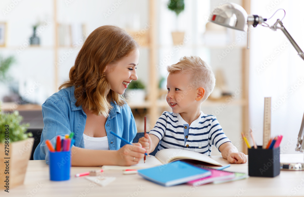 mother and child son doing homework writing and reading at home mother and child son doing homework writing and reading at home