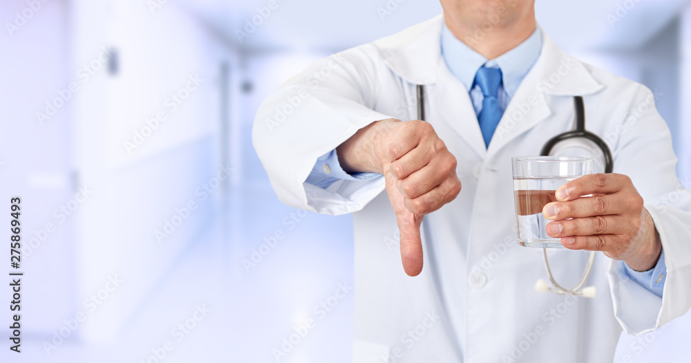 doctor hands holding a water glass with thumbs down doctor hands holding a water glass with thumbs down