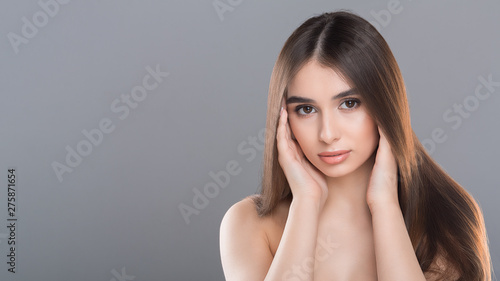 Beauty portrait of young gorgeous woman, grey background