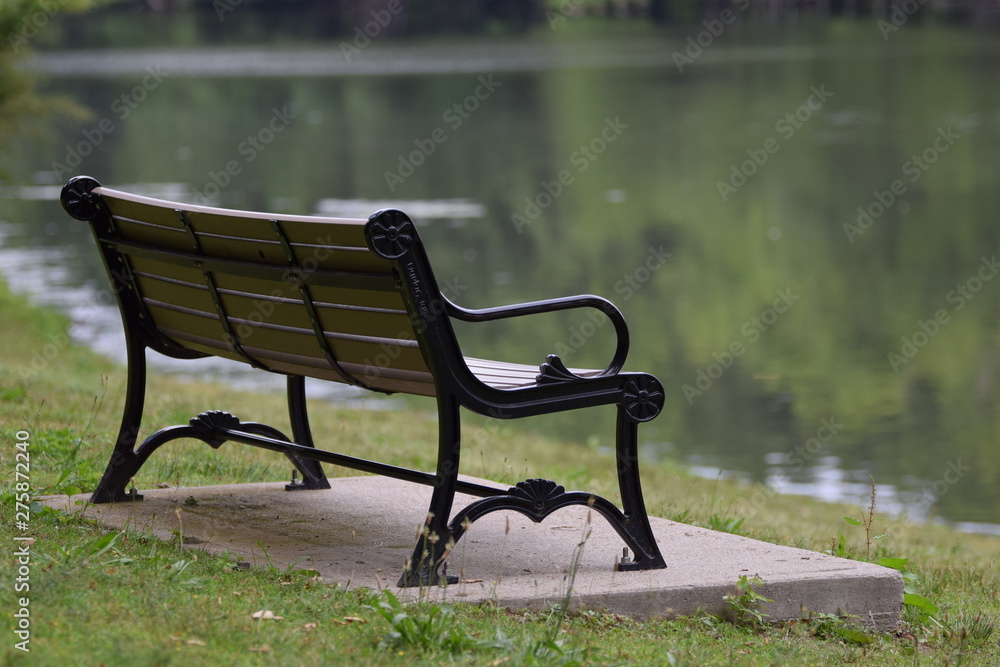 A bench in the park alongside lake A bench in the park alongside lake
