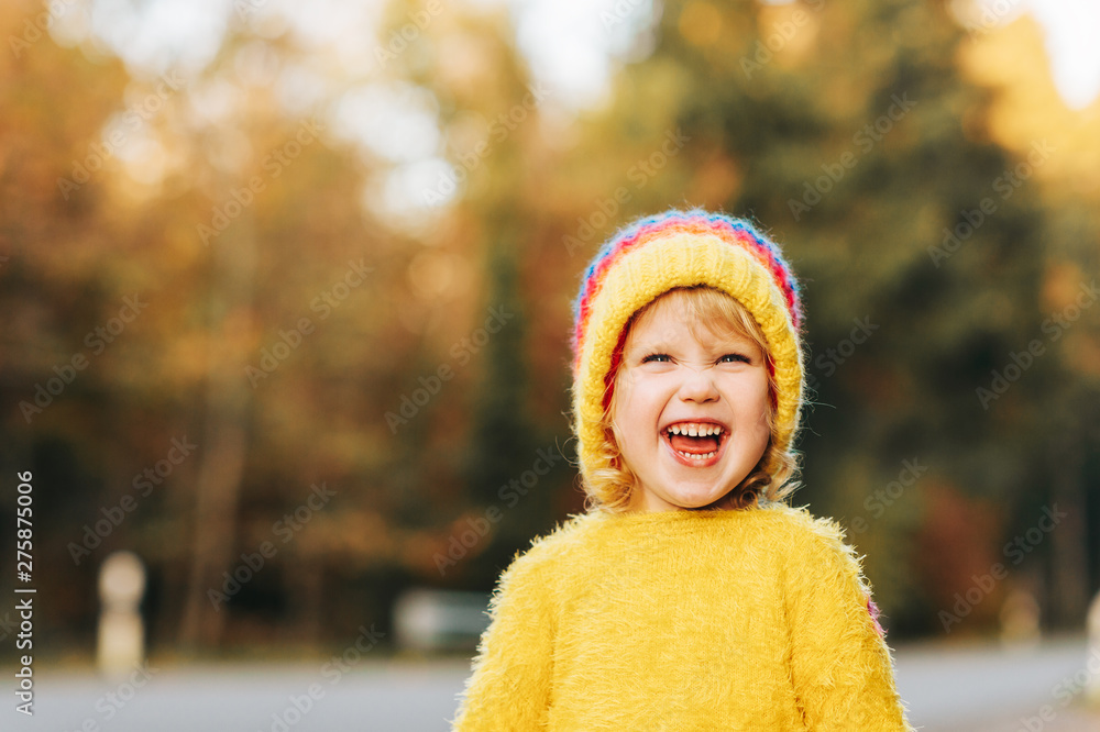 Outdoor portrait of cute toddler girl wearing yellow hat and pullover Outdoor portrait of cute toddler girl wearing yellow hat and pullover