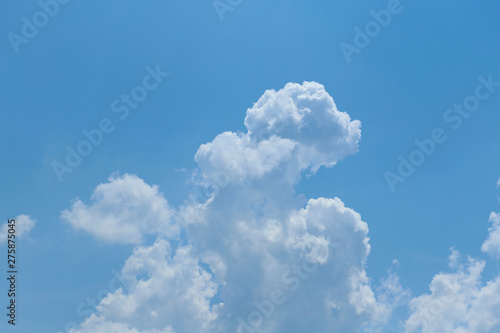 Blue sky background with fluffy white clouds at the bottom. Cropped shot, horizontal, nobody, free space at the top. Nature concept. © Nataliia