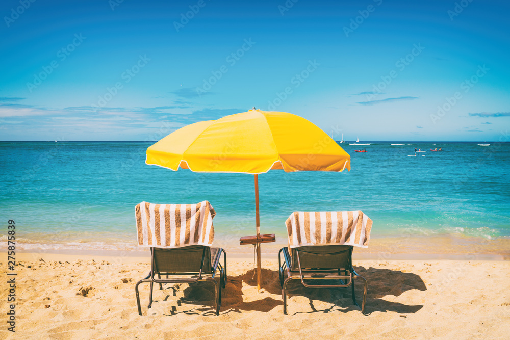 Beach holiday lounging chairs under sun umbrella vacation background. Summer tropical travel destination.