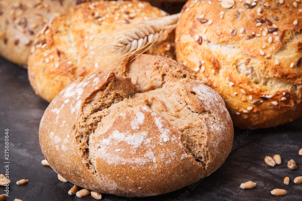 Wholegrain rolls or bread with seeds and ears of rye grain