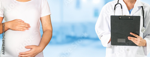 Happy pregnant woman visit gynecologist doctor at hospital or medical clinic for pregnancy consultant. Doctor examine pregnant belly for baby and mother healthcare check up. Gynecology concept. photo