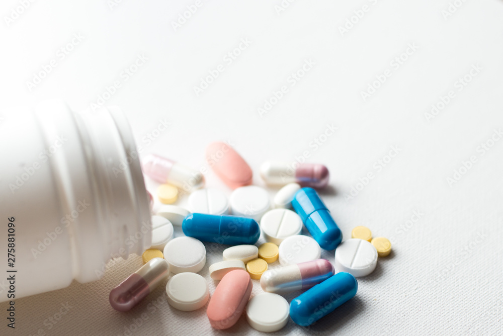 Medicine pills or capsules on white background with copy space. Drug prescription for treatment medication. Pharmaceutical medicament, cure in container for health. Antibiotic