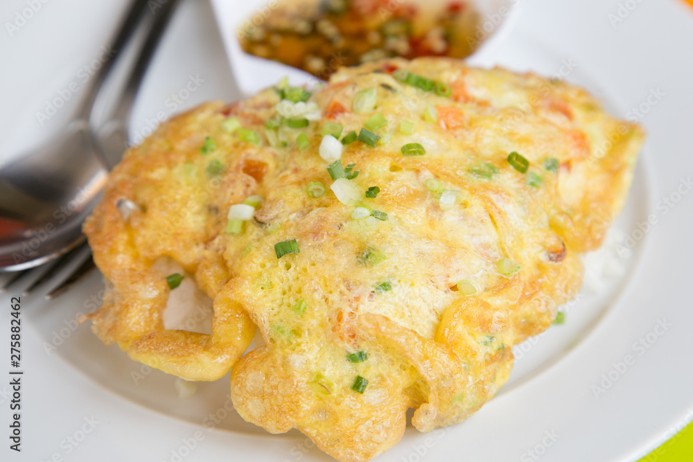 fries golden omelet on top with rice food on white dish plate meal