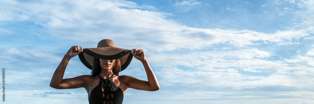 Elegant mysterious fashion woman wearing floppy hat hiding eyes over face in black sexy stylish outfit banner panorama.
