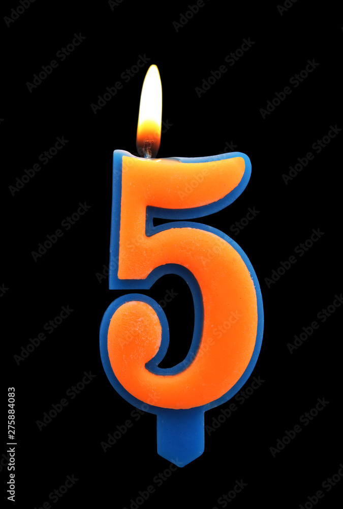 Burning birthday candle isolated on black background, number 5 Burning birthday candle isolated on black background, number 5