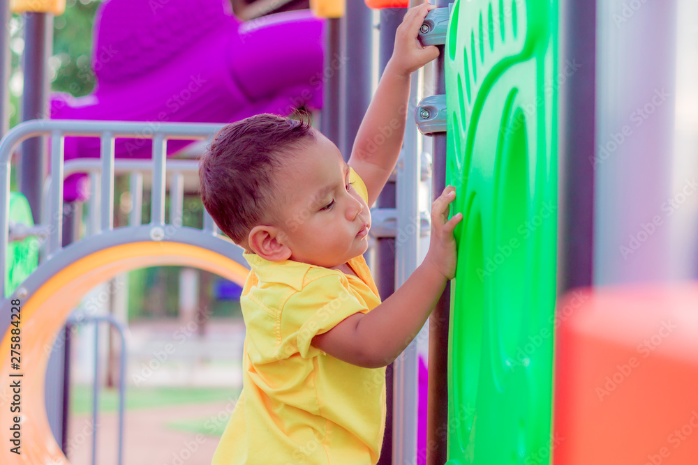 Fototapeta premium Children are having fun At the playground. asian cut little boy in the park at thailand