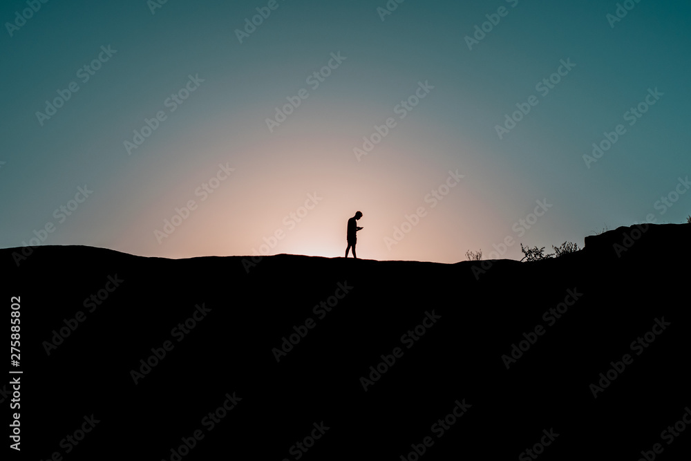 silhouette of man on top of mountain