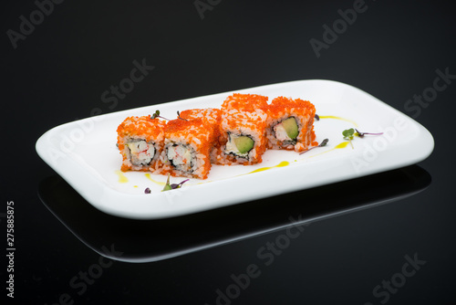 sushi in a plate on a black background with reflection. fish roll