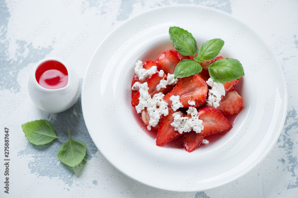 Strawberry dessert served in a white plate, studio shot over white concrete background Strawberry dessert served in a white plate, studio shot over white concrete background