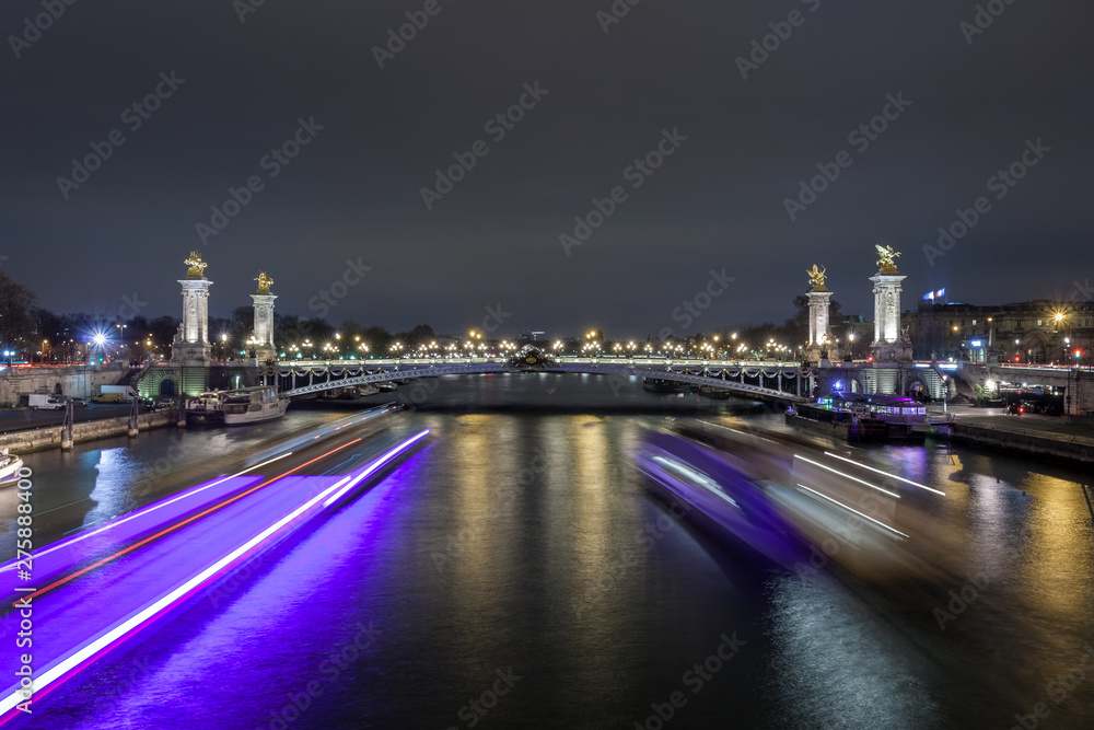 Pont Alexandre III in Paris at night. This bridge is one of the most beautiful and decorated bridges in the world and is located in the Invalides area.