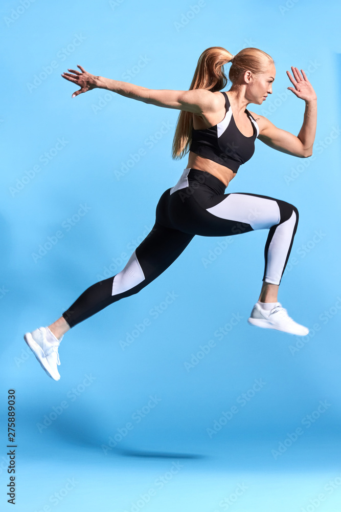 strong sportswoman taking part in the competition, isolated blue background, studio shot.strength, body and health care. wellness, wellbeing.