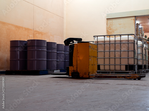 Low light inside of the old factory. The large white and purple tanks chemical packaging.