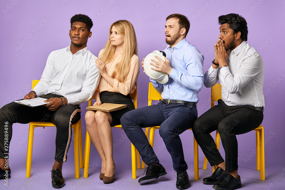 multicultural construction project team received upset and shocking news sitting in a row waiting for job interview multicultural construction project team received upset and shocking news sitting in a row waiting for job interview