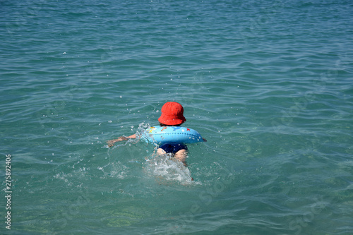 Little boy with inflatable ring swimming in the sea. Child with a floating ring enjoy in water © Ivan