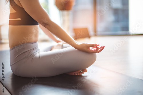 Young woman practicing yoga in gray background.Young people do yoga indoor at home.