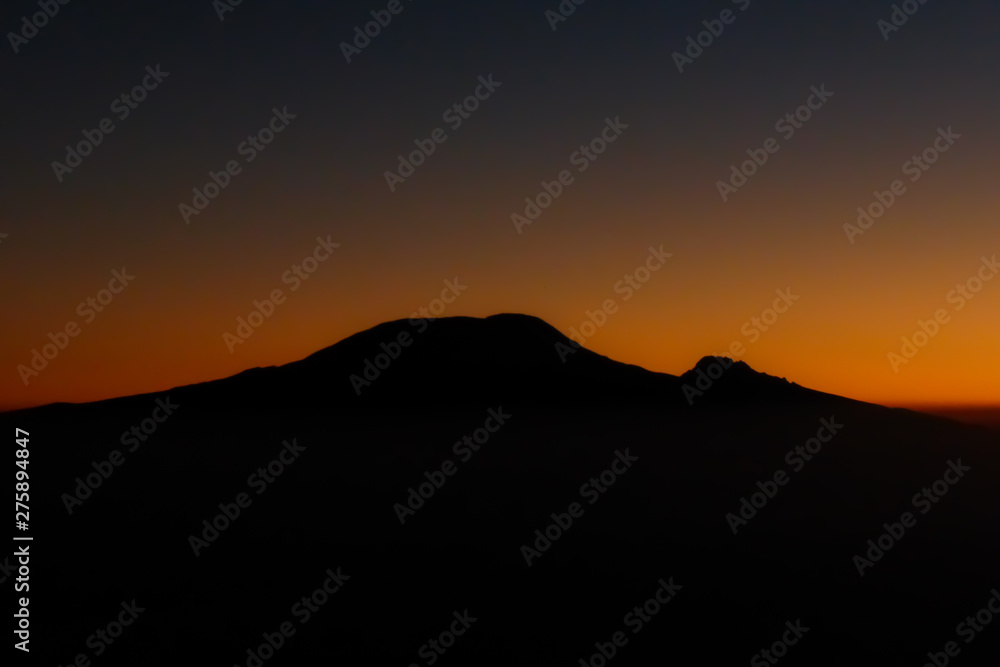 sunrise over the silhouette of Mount Kilimanjaro and Mawenzi in Tanzania sunrise over the silhouette of Mount Kilimanjaro and Mawenzi in Tanzania