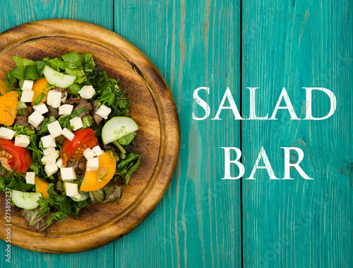 Healthy food concept - Fresh vegetable salad with greenery, tofu, tomatoes, cucumber and text Salad bar