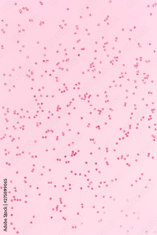 scattered pink holographic glitter confetti star shaped on pink background Flat lay top view copy space. Festive holiday pastel backdrop. Birthday, congratulations, Christmas, New Year scattered pink holographic glitter confetti star shaped on pink background Flat lay top view copy space. Festive holiday pastel backdrop. Birthday, congratulations, Christmas, New Year