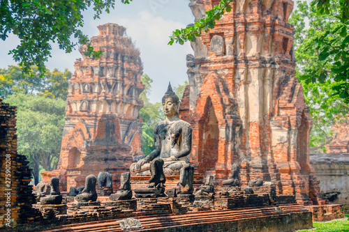 Only intact ancient Buddha statue among the destroyed statues in Ayutthaya historical park, Thailand. photo
