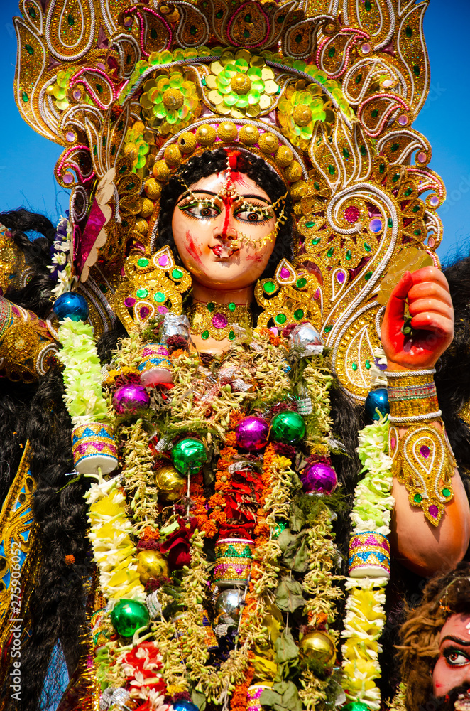 Golden and colorful statue of ten handed goddess Durga being worshiped with flower on the occasion of durga puja in Kolkata, India.