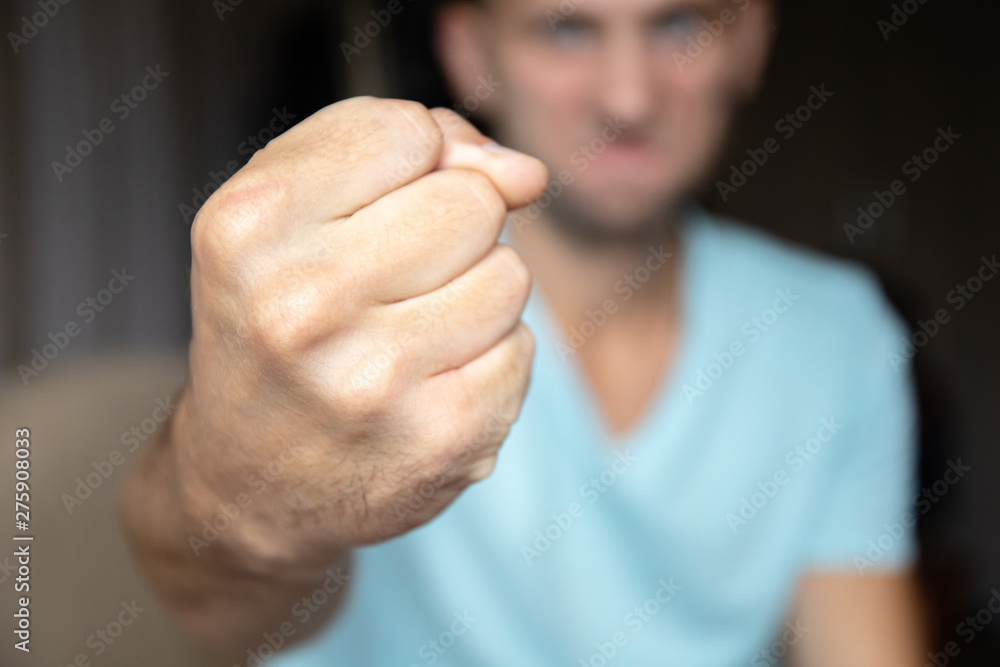 male fist close up violence concept, angry male face on background