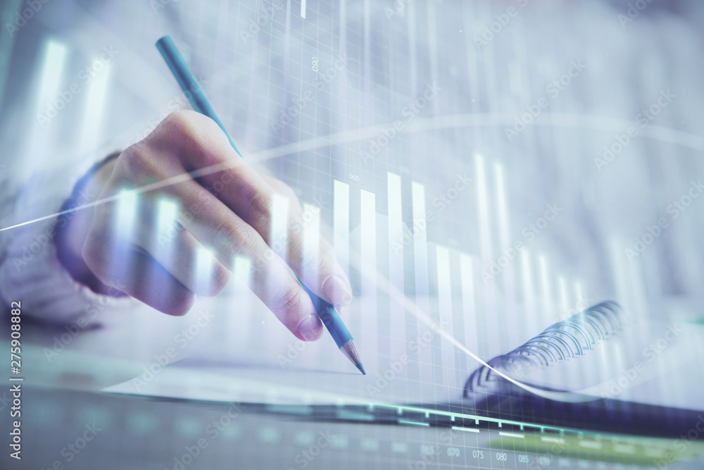 Financial forex graph displayed on hands taking notes background. Concept of research. Double exposure Financial forex graph displayed on hands taking notes background. Concept of research. Double exposure