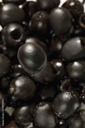 black olive flies over other olives