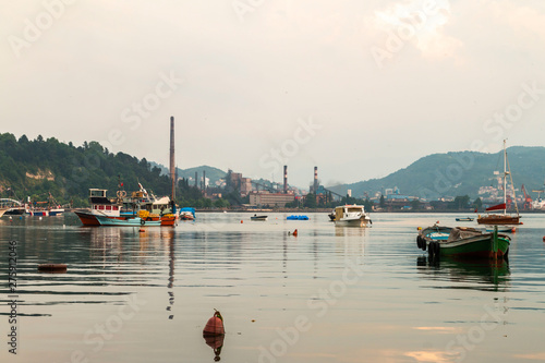 Zonguldak eregli district, fishing boats and erdemir iron and steel factory behind June 24,2019, Eregli, Zonguldak, Turkey photo