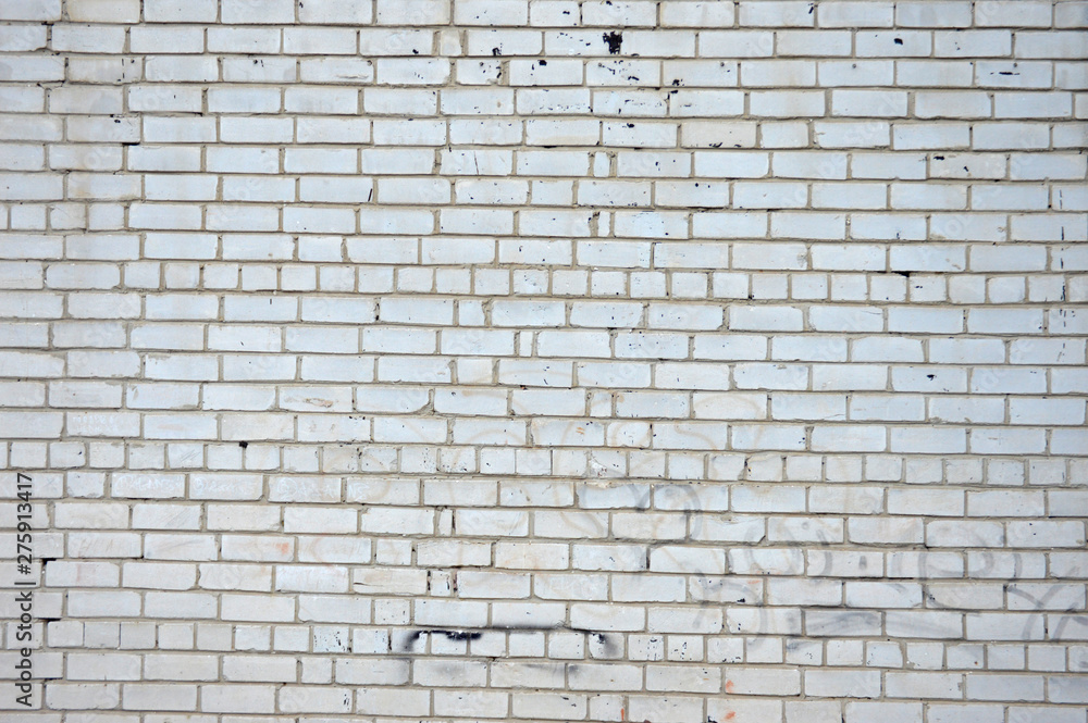 Obraz premium The texture of the facade of the building of white, damaged brick. Wide white wall background