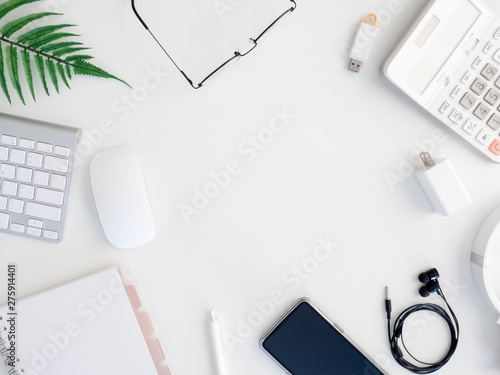 top view of office desk table with calculator, notebook, plastic plant, smartphone and keyboard on white background, graphic designer, Creative Designer concept.