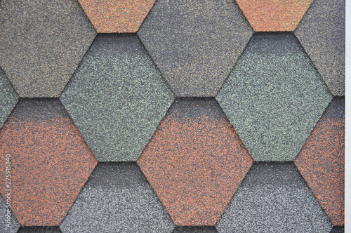 The texture of multi-colored tiles for the roof of the building. Crumbs of asphalt and rubber