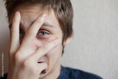 Teen boy covers his face with his hand and screams