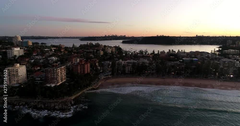 Flying up and panning facing Manly beach with surfing waves ashore popular recreational and tourist destination in Australia, Sydney. Flying up and panning facing Manly beach with surfing waves ashore popular recreational and tourist destination in Australia, Sydney.