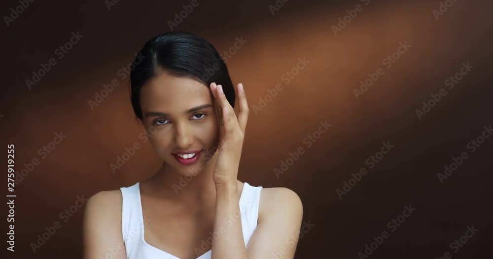 Portrait of the charming young Caucasian brunette girl in the white T-shirt smiling cheerfully and posing to the camera. Close up. Portrait of the charming young Caucasian brunette girl in the white T-shirt smiling cheerfully and posing to the camera. Close up.