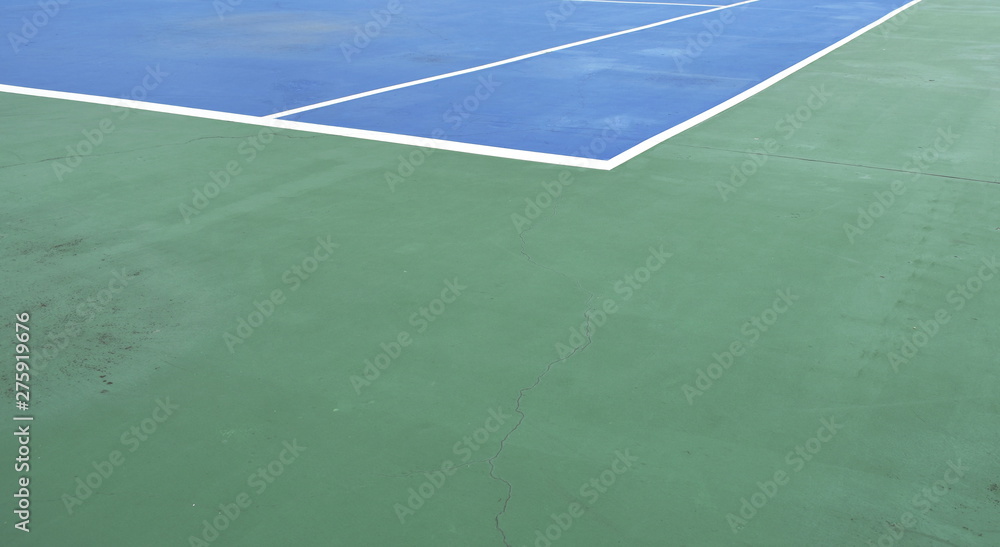 blue tennis court with white border line on green floor